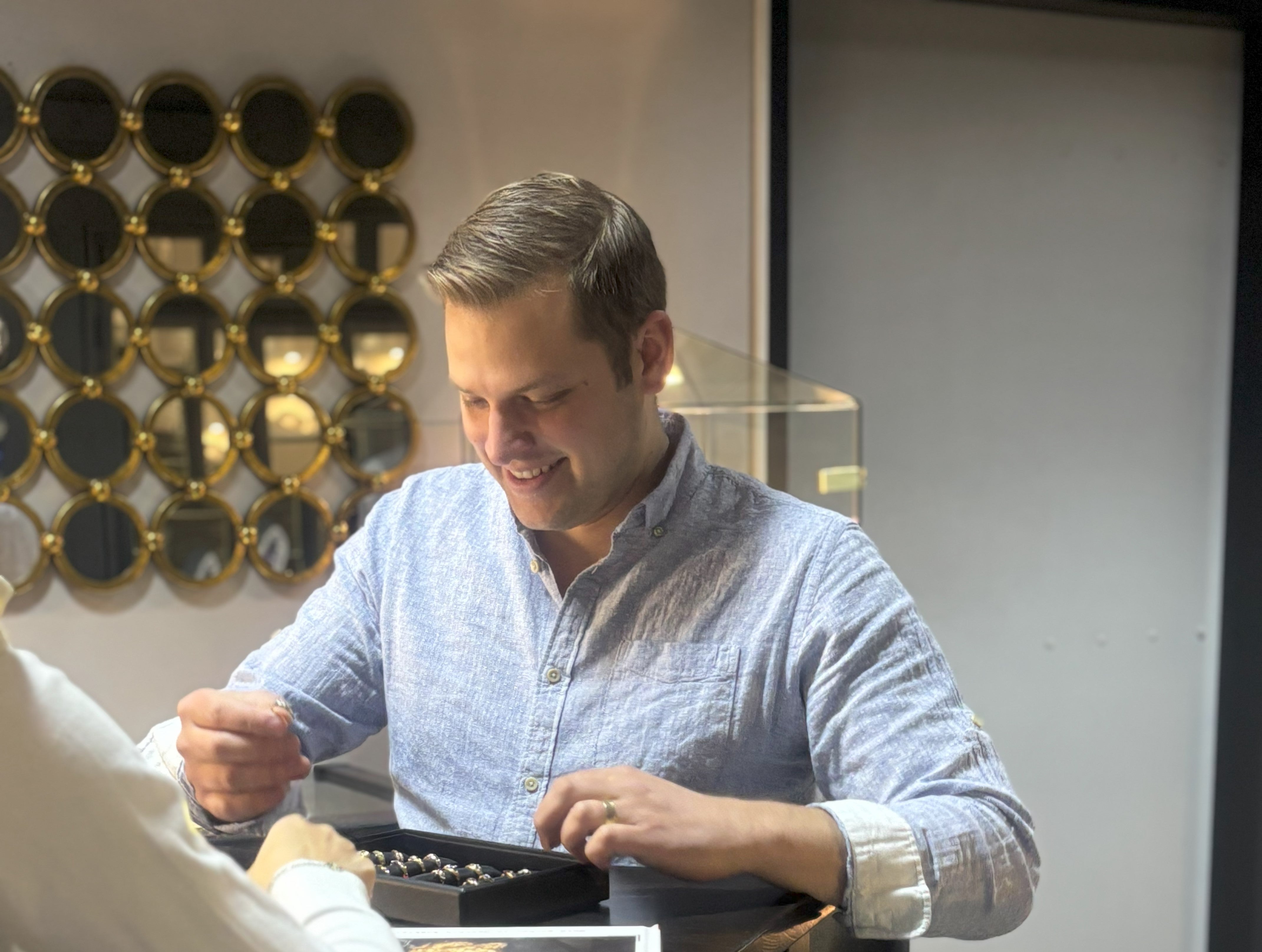 Marcel Ahlden begutachtet Schmuck im Laden – Edelmetallrecycling & Altgoldankauf