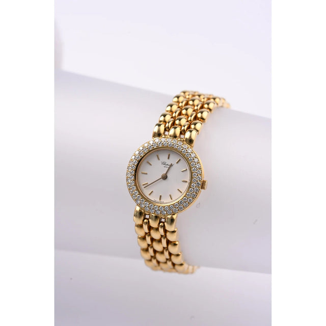 Chopard Damenuhr 18K Gelbgold mit Diamantluenette, komplette Frontansicht auf Uhrenstaender mit Goldarmband