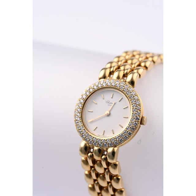 Chopard Damenuhr 18K Gelbgold mit Diamantluenette und weissem Zifferblatt, Schraegansicht auf Uhrenstaender