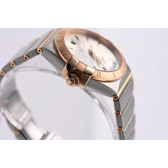 Omega Constellation Co-Axial Day-Date 38 mm Edelstahl/Rotgold, perspektivische Ansicht mit Armband und Griffes-Krallen