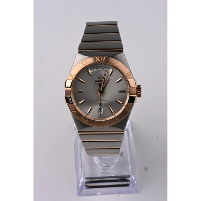 Omega Constellation Co-Axial Day-Date 38 mm Edelstahl/Rotgold, Schraegansicht mit Krone und Rotgold-Luenette